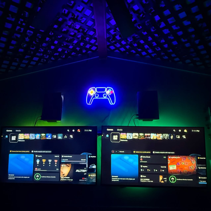 thesupercolliesmom’s multiplayer gaming space with two wall-mounted TVs, dual PlayStation consoles in HIDEit PS5 Mounts, and vibrant LED lighting for a family gaming room setup.