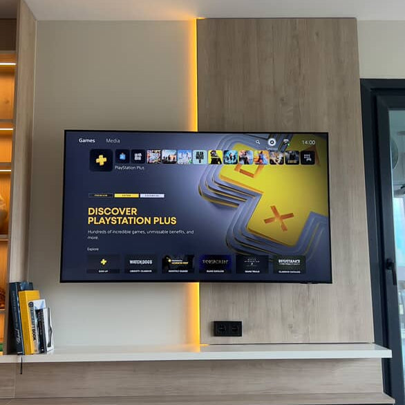 Selcuk’s afterHIDEit setup with a PS5 hidden behind the wall-mounted TV using a floating console mount for a clean media wall with LED backlighting.