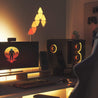 Nanoleaf triangle lights shown in warm colors lighting up gaming desk.