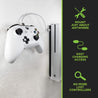 Xbox video game controller wall mounted next to Xbox console for easy access and charging.