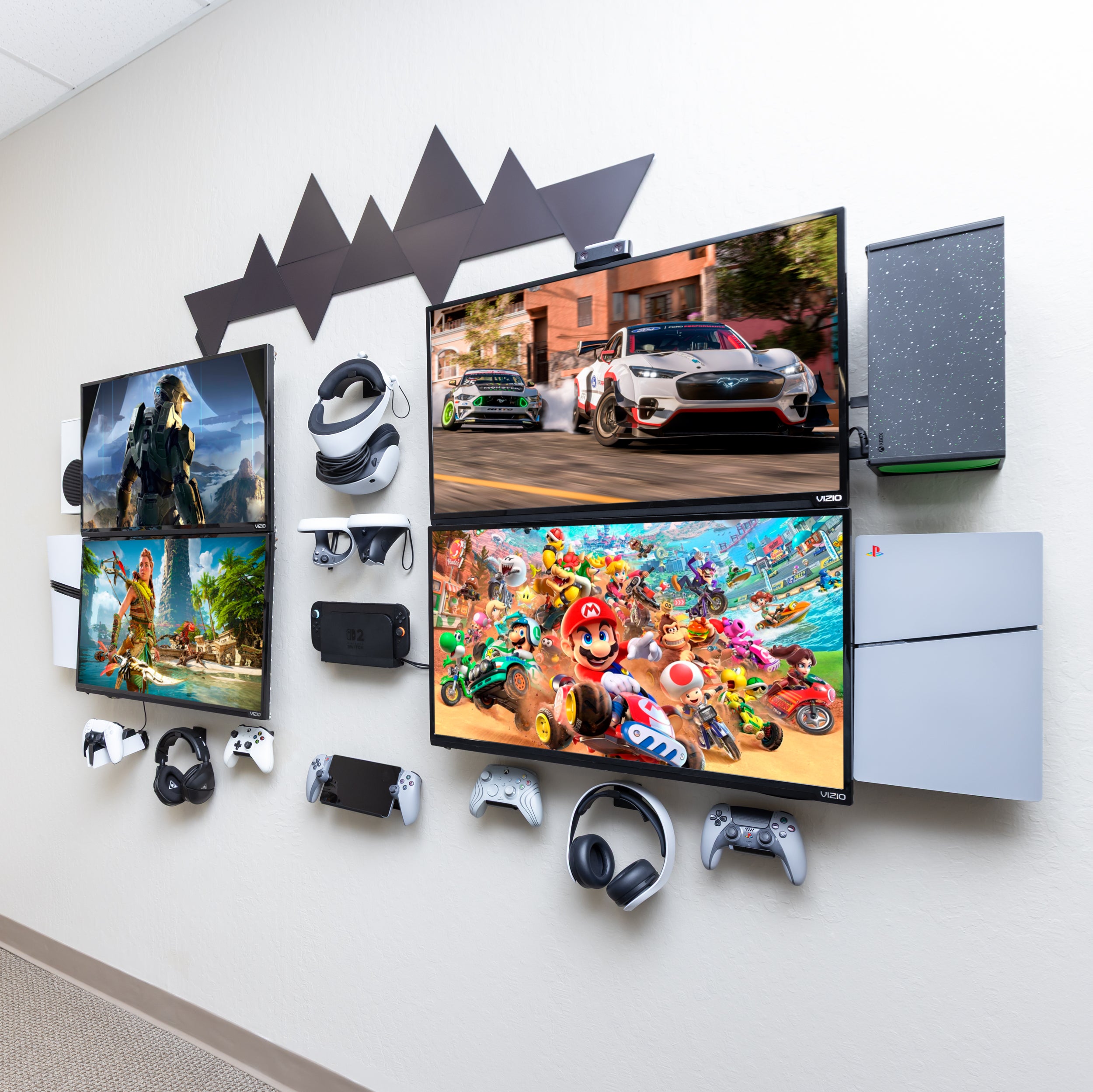 HIDEit headquarters gaming setup at with multiple monitors, controllers, and a gaming consoles all wall mounted using HIDEit Mounts.