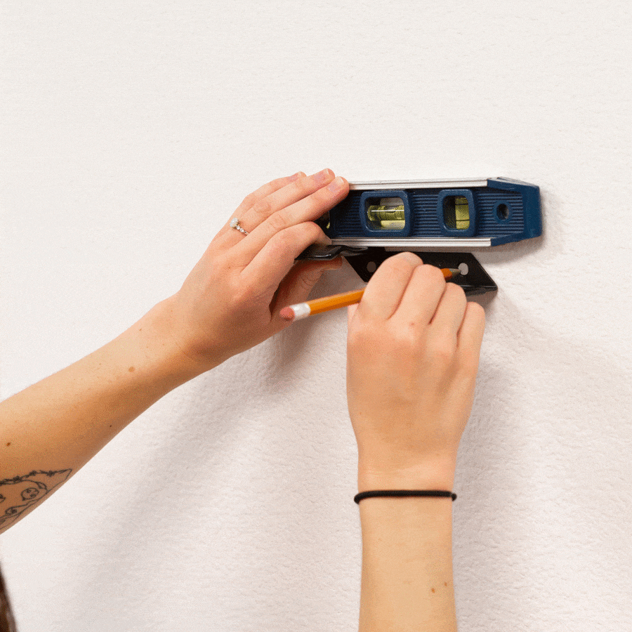 Gif of a woman installing a HIDEit Horizontal Bat Mount on the wall with an Old Hickory Bat.