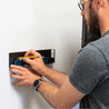 Gif of a man installing a HIDEit Original PlayStation 4 Mount on the wall with an Original PS4 console.