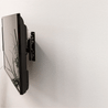 Gif of a woman installing a HIDEit Xbox One X Mount on the wall with an Xbox One X console.
